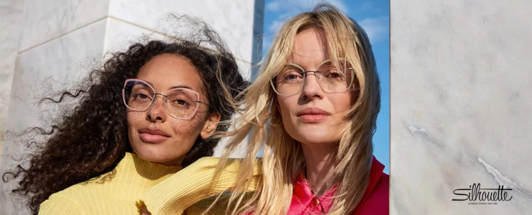 Duas mulheres usando óculos modernos em ambiente externo.