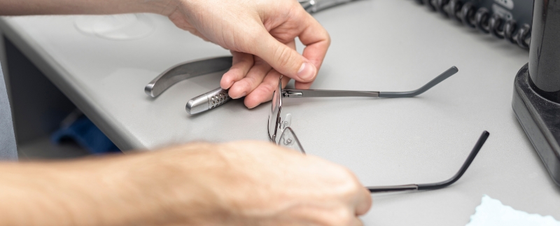 Pessoa ajustando óculos em mesa de trabalho