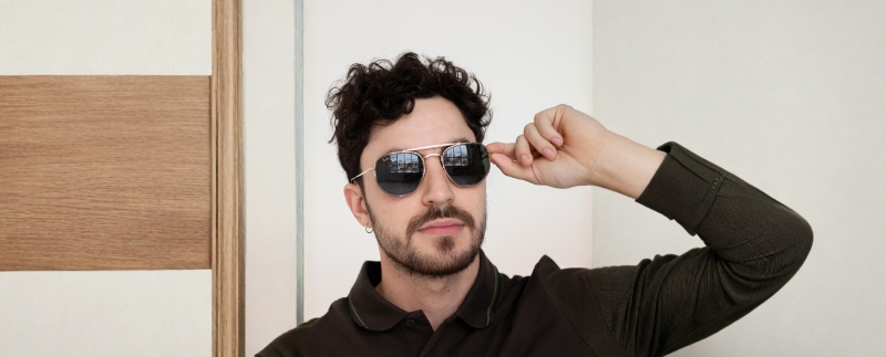 Homem com óculos escuros em ambiente interno