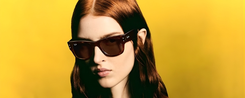 Modelo usando óculos de sol em fundo amarelo