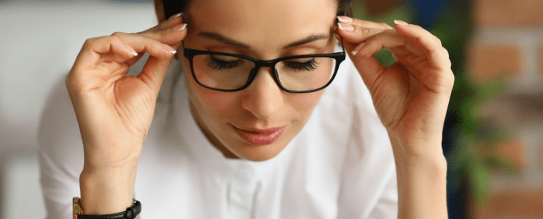 Mulher ajustando óculos em ambiente de trabalho
