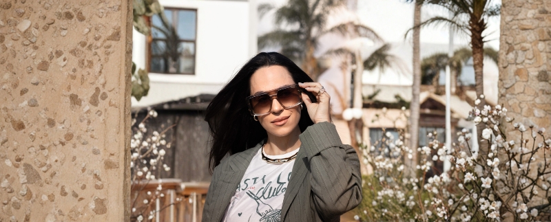 Mulher com óculos em ambiente com flores