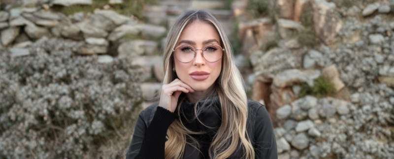 Mulher loira com óculos em ambiente natural