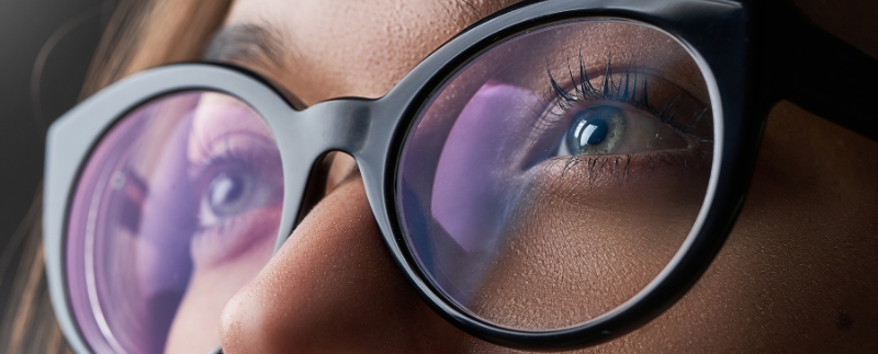 Detalhe dos olhos por trás de óculos com lentes coloridas