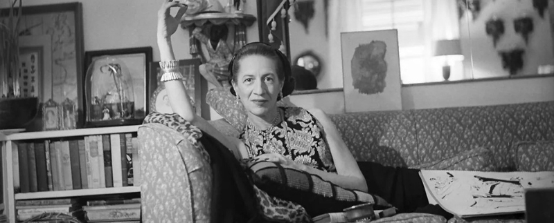 Mulher relaxando em sofá, retrato artístico em preto e branco.